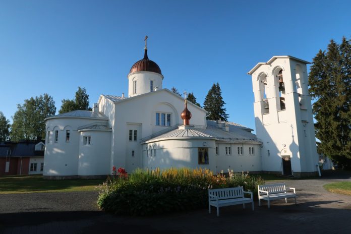 Valkoinen kirkko sinistä taivasta vasten.