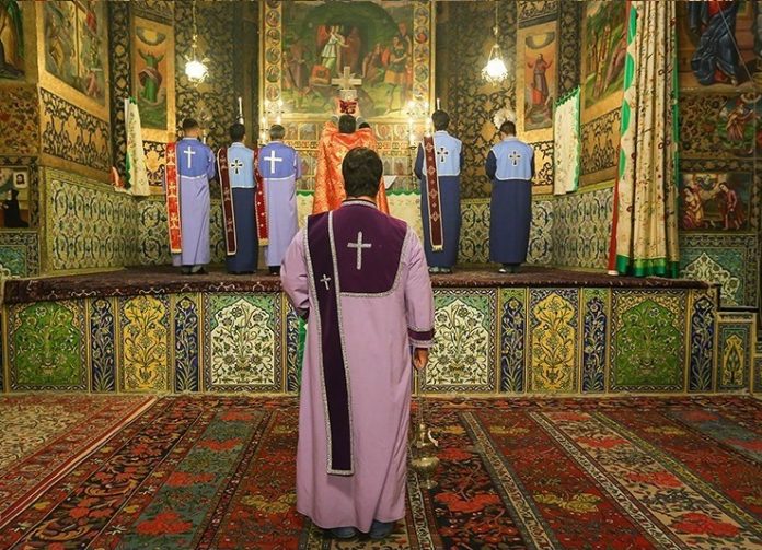 Vank, armenialainen katedraali Isfahanissa Iranissa by Tasnim News_Creative commons New_Year's_Eve_celebrations_at_Vank_Cathedral,_Isfahan_(25) Armenialaisia pappeja Vankin katedraalin alttarilla selin kameraan Isfahanissa Iranissa.