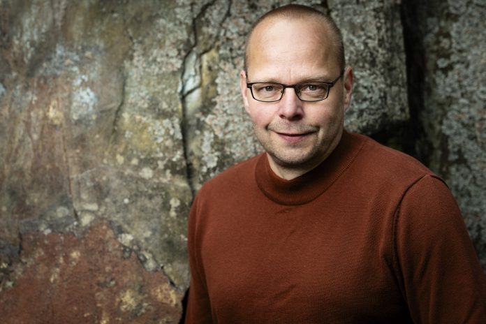 Roope Lipasti Kirjailija Roope Lipasti yllään viininpunainen pitkähihainen paita.